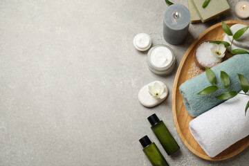 Fototapeta na wymiar Flat lay spa composition with skin care products on grey textured table, space for text