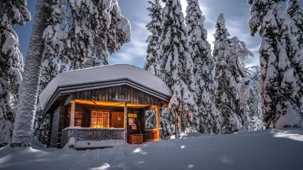A public wilderness cabin in snow covered spruce tree forest in Pyhä-Luosto National Park, Lapland, Finland, night time lapse