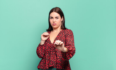 young pretty casual woman feeling disgusted and nauseous, backing away from something nasty, smelly...