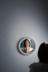 Reflection of a woman's face in broken mirror. Depression, anxiety, phobia, suicide and mental health concept.
