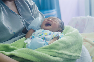 Newborn, female, asian Resting on a hospital bed With mother feeding Baby photography ideas for you