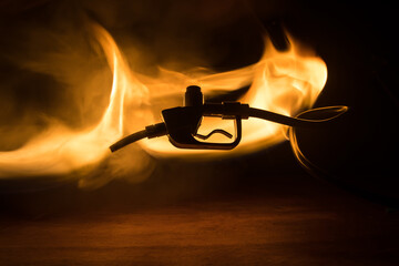 Creative concept. Silhouette of gasoline pistol miniature on dark toned foggy background. Close up....