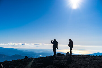 富士山。登山。絶景の写真と撮る人物のシルエット。
