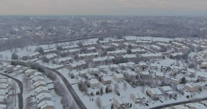 Amazing aerial with small town USA main street hometown the a after snowfall severe winter weather conditions in snow trees covered