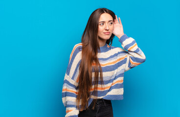 young pretty casual woman looking serious and curious, listening, trying to hear a secret...