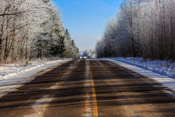 Highway E running through a frost covered forest in northern Wisconsin in January