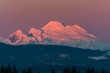 Snow capped Mount Baker at sunset in pink alpenglow atop the prominent member of the Ring of Fire in Washington State which is also visible from Canada © IanDewarPhotography