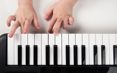 learning to play the piano,little girl hands on synthesizer keys