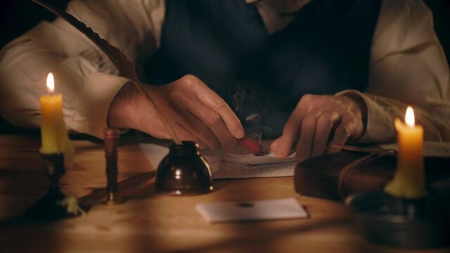 An 18th century scene of a man in a room lit by light from an overhead window and candles using sealing paraffin and a wax stamp to secure the letter he has written.