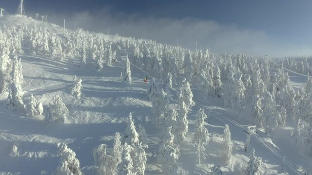 Winter ski resort on Rukatunturi hill in Kuusamo, Lapland, Finland, aerial drone shot