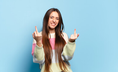 young pretty casual woman feeling provocative, aggressive and obscene, flipping the middle finger,...
