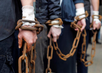 chain on hands of chained together men close up