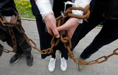 chained woman and men hands together close up.
