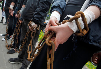 group of people stand with chained hands close-up