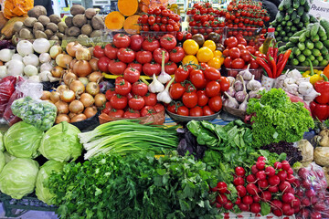 various fresh and juicy vegetables greens, tomatoes, cabbage, onions, parsley, potatoes, salad, garlic, pepper and radish on a market counter, market trading..