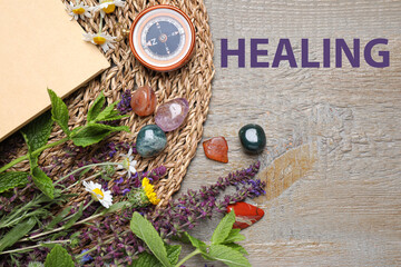 Flat lay composition with different gemstones and healing herbs on wooden table