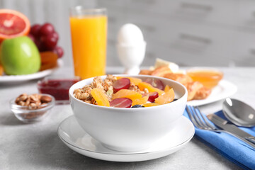 Delicious granola with fruits served on white table