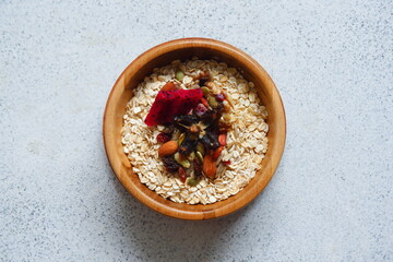 a bowl of oats with nuts and dried fruits in white background