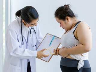 Doctor use measure tool to measure the thickness of fat at the belly of a woman.