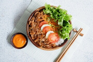 chicken teriyaki rice bowl with salad and sauce in white background