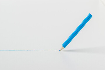 A blue pencil draws a line on a white background.