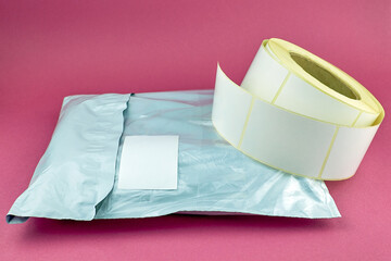 Self-adhesive stickers for marking goods or parcels. Roll of white labels and package