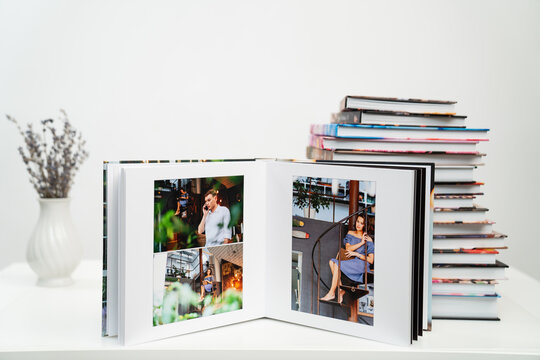 stack of books. open photobook from photo shoots of a beautiful happy couple 