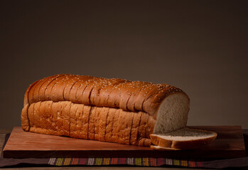 Pan de caja con ajonjolí en rebanadas sobre tabla de madera