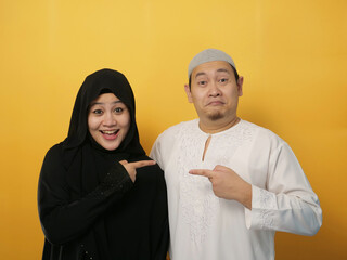 Happy Asian muslim couple proud of each other, pointing and smiling, lovefamily  good relationship