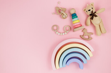 Wooden baby toys on a pastel pink background.  Horse, pyramid, rainbow, bear. Set of accessories for children. Early education, imagination, 
grasping training. 