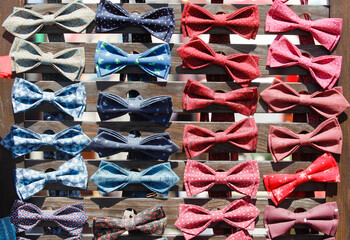 a lot of multicolored men's bow ties on the counter on street