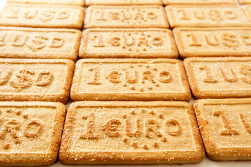 Row of sugar cookies with the USD and EUR currency symbols , background