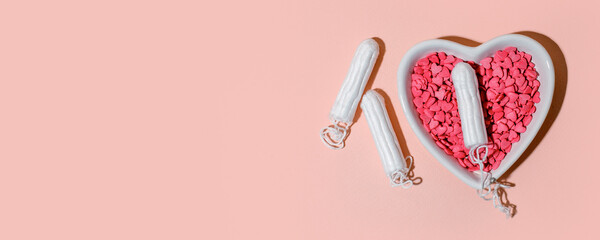 Medical female tampons and heart shape plate on pink background. Hygienic white organic tampon for women. Menstruation, means of protection. Stylish minimal concept, banner, flyer, hard shadow
