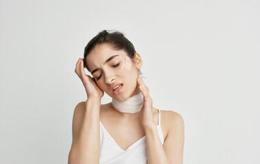 Fototapeta premium woman in white t-shirt bandaged neck health problems