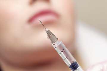 Close up Needle from an injection in a beauty salon. There is a small drop of liquid at the tip of the needle.