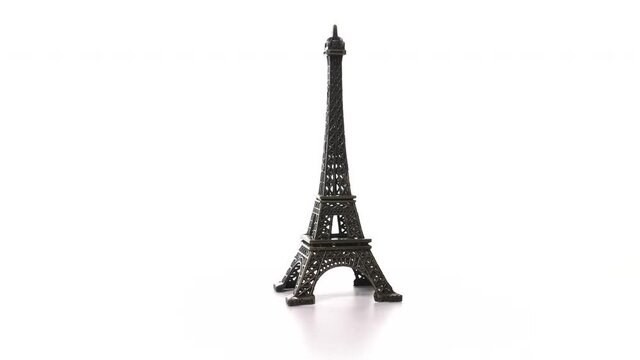 toy metal eiffel tower spins on turntable. Rotation of historic symbol of France with inscription Paris. Miniature replica of the tall tower