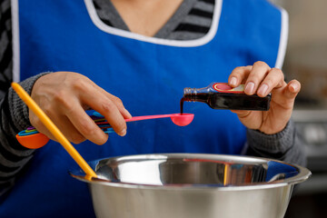 Agregando vainilla en recipiente para preparar un panque de plátano. concepto de repostería en casa