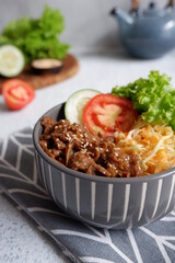 beef teriyaki rice bowl with vegetables in a white background