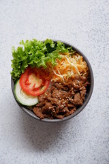 beef teriyaki rice bowl with vegetables in a white background