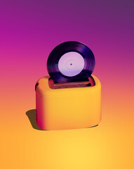 Vinyl record in a toaster against a yellow-pink gradient. Creative concept of hot music and good...