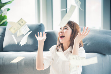 Happy young asian woman holding dollar money and throw in the air celebrate happiness dance wealth...