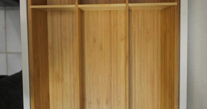 One piece of every type of cutlery put neatly in the drawer of the kitchen cabined as a minimalist organizing system