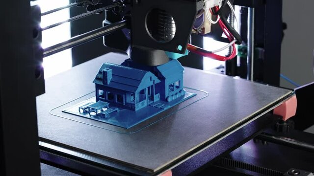 Close up of 3d Printer printing small blue house  shot in 4k