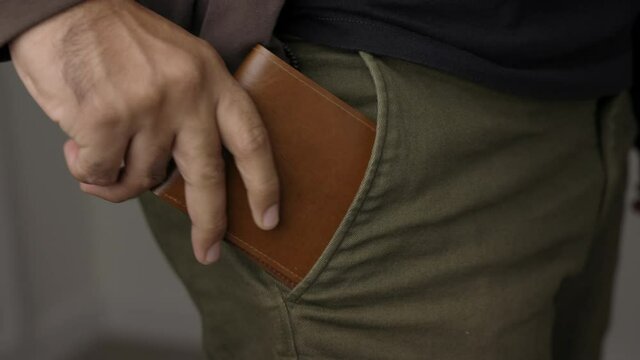 Close up male hand put out the wallet from his jean pocket. Showing the wallet . Financial business concept.
