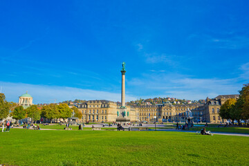 People are walking and resting on the Schlossplatz plaza in Stuttgart, near the New Palace, which was built between 1746 and 1807.