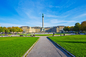 People are walking and resting on the Schlossplatz plaza in Stuttgart, near the New Palace, which...