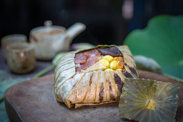 Streamed rice in lotus leaf, Stream rice with herb beans, lotus seed, ginkgo, egg yolk and soy sauce in lotus leaf. 
