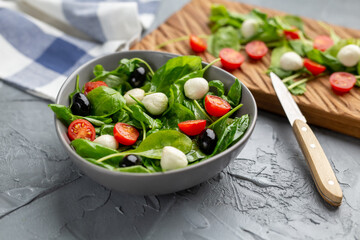 Fresh salad with mozzarella cheese, tomato and spinach. Healthy dieting food.