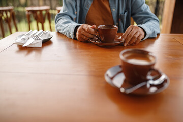 Woman sit by the table in outdoor cafe