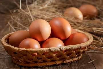 Fresh brown chicken eggs in a basket and in a nest from hay in a barn